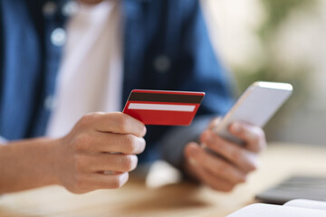 Online Payments. Man using credit card and smartphone for e-commerce