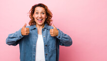 Middle Age Hispanic Woman Smiling Broadly Looking Happy, Positive, Confident And Successful, With Both Thumbs Up