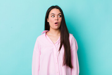 Wall Mural - young adult woman feeling shocked, happy, amazed and surprised, looking to the side with open mouth