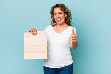 Wall Mural - middle age woman feeling proud,smiling positively with thumbs up. take away concept