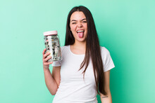 Young Adult Woman With Cheerful And Rebellious Attitude, Joking And Sticking Tongue Out. Savings Concept