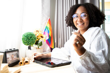 Africa American Lesbian, Beautiful Gay Working On Tablet With Love Moment Spending Good Time Together, Lgbt Rainbow, Pride Flag On Table Near Curtain At Window.