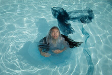 Art Portrait Of Asian Woman Underwater In The Swimming Pool In Blue Dress