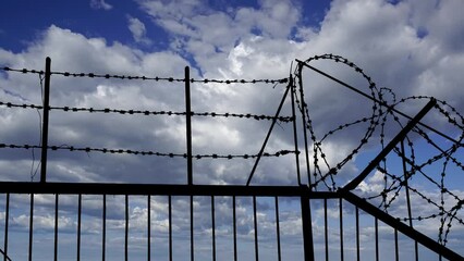 Wall Mural - Сontour of barbed wire on background beautiful clouds and sky