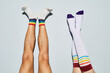 © Seventyfour - Minimal shot of playful young couple wearing socks with rainbow symbols feet up against white wall
