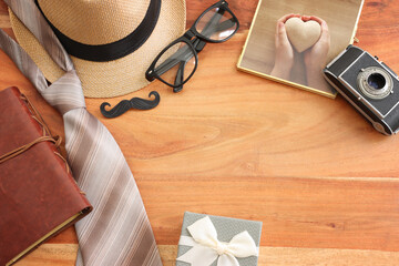 Wall Mural - Father's day and travel concept with fedora hat and necktie over wooden background. top view, flat lay