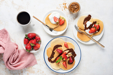 Wall Mural - Breakfast pancakes with strawberries, yogurt and chocolate sauce. Top view. Family sweet breakfast pancakes served