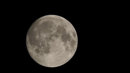 Wall Mural - Full moon on dark black sky background, shot from surface of earth with very long telephoto lens. Grey white moon glowing at clear sky.