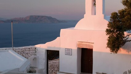 Wall Mural - View of the beautiful whitewashed orthodox chapel Panagia Palaiokastritissa in Ios Greece, while the sun is setting and the aegean sea in the background 