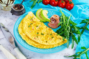 Wall Mural - Fried omelette with ham, onion and herbs. Breakfast with scrambled eggs