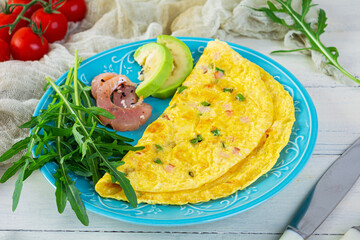 Wall Mural - Fried omelette with ham, onion and herbs. Breakfast with scrambled eggs