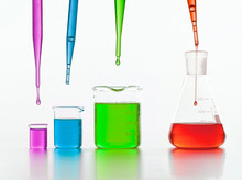 Set Of Laboratory Test Flasks With Colorful Liquids In White Studio