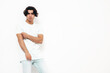 © halayalex - Portrait of handsome confident  stylish hipster lambersexual model.Man dressed in over size T-shirt and jeans. Fashion male isolated in studio. Posing near white wall
