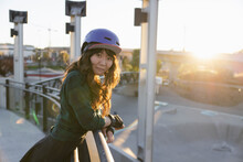 Portrait Of Asian Woman In Helmet On Ramp In Skatepark