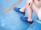 Fototapeta Desenie - Female fashion in boat shoes leather, Close up view on woman's legs in gray jeans and navy blue shoes leather.