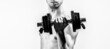 © Yevhen - Man holding dumbbell in hand. Skinny guy hold dumbbells up in hands. Weak man lift a weight, dumbbells, biceps, muscle, fitness. Nerd maleraising a dumbbell