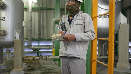 Wall Mural - Industrial Worker in oil refinery plant, wearing personal protection equipment and working in production plant 