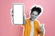 © Kateryna - Excited happy black and white african american girl, holding smart phone in her hand with blank white mock-up screen for presentation, stands on isolated pink background, smiling. Cut out concept