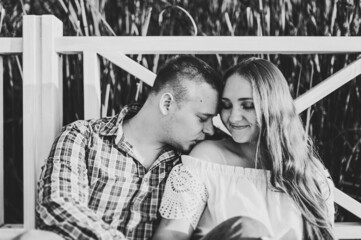 Wall Mural - Couple hugging and kissing at sunset on pier. Black and white photo.