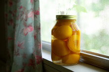 Jar Of Pickled Peaches In Windowsill