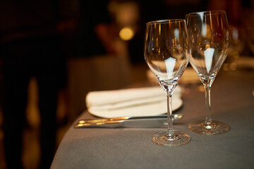 table setting. two glasses for wine are on the table. wine glasses are on the table. Two glasses in bar on bright background. two glasses for wine