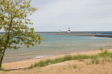 Sand beach and beachgrass with St. Joseph North Pier Inner Lighthouse and St. Joseph North Pierhead Outer Lighthouse, Michigan in background