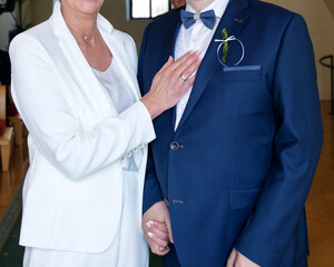 Bride's hand with a wedding ring on the groom's chest. Love union of two adults.