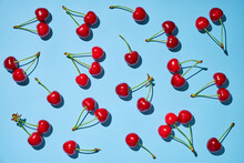 Fresh Ripe Red Cherry With Stalks On The Blue Background.