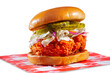 Spicy fried chicken sandwich with pickles and coleslaw on a white background; copy space