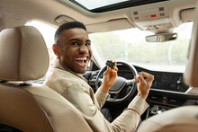 Joyful African American Guy Holding Auto Key Shaking Fists Sitting In Automobile 
