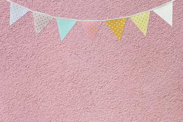 Flag garland on pink cement wall texture background, festival and event background concept