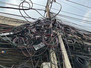 Plenty of electric wires along the road poles.