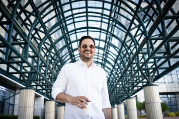 Wall Mural - Business man portrait. Man standing in front of office building