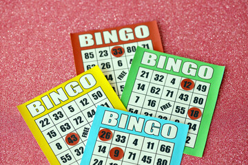 Many colorful bingo boards or playing cards for winning chips. Classic US or canadian five to five bingo cards on bright background