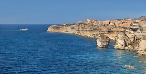 Wall Mural - Bonifacio coastline with limestone cliff in the sea under clear blue sky in Corsica- France