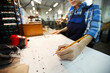 © Mediaphotos - Close-up of busy engineer standing at desk and making points on technical card while working at factory