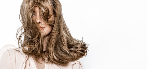 Portrait of a beautiful natural girl with beautiful healthy hair on a white background. A beautiful young girl with a perfect face and beautiful flowing hair. Beauty hair - concept.