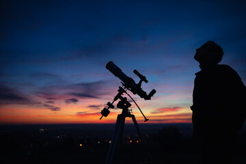 Wall Mural - silhouette of a man, telescope and countryside under the starry