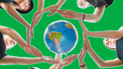 Wall Mural - Schoolgirls hug the earth globe with their hands, making a circle out of them on a green background.