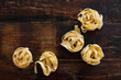 Raw fettuccine noodles are on the wooden kitchen table. View from the top point. Copy space.