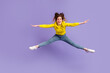 © Tetiana - Full length photo of young girl have fun jump up sportive wear modern outfit isolated over purple color background