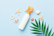 Sunscreen Spray Bottle. Bottle With Sun Protection Cream And Sea Shells With Tropical Green Leaf On Color Background, Top View