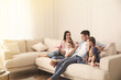 © New Africa - Happy family resting on comfortable sofa in living room