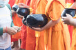 © Monta - Young Buddhist monks or novice monk are given food, drinking water,banknotes offerings from people.