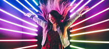 Attractive Dancing Girl, Hair Flying, Neon Light. Portrait Of Girl Posing With Hands Up.