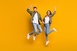 © deagreez - Full size photo of young excited couple energetic jump rejoice victory success yes fists hands isolated over yellow color background