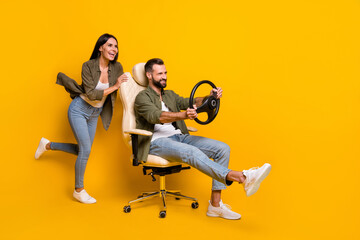 Wall Mural - Full size profile side photo of young girl guy sit stool play videogame fast speed transport isolated over yellow color background