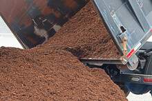 A Dump Truck Delivers A Large Load Of Mulch Or Wood Chips Use For Landscaping Top Ground Material And Accents.