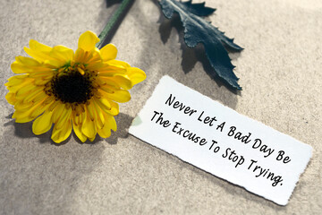 Wall Mural - Motivational quote on torn white paper on wooden surface with sunflowers.