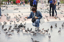 Woman Feeding Pigeons On Square. Travel Around Europe, Spain, Barcelona. High Quality Photo